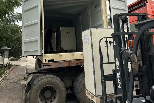 Forklift loading packaged hydraulic equipment into a container for international shipping