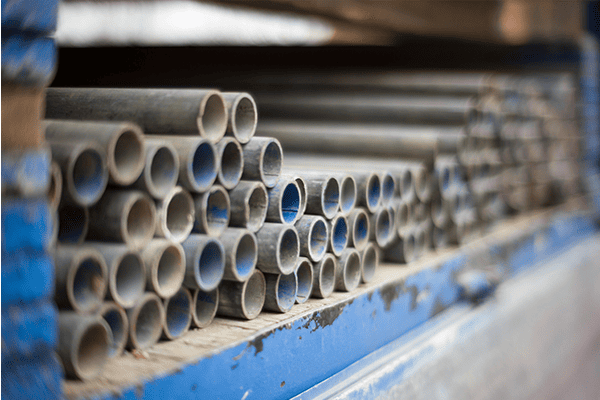 Stacked steel pipes on storage rack, Industrial piping for construction projects