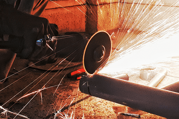 Angle grinder cutting steel pipe, Sparks flying during precision pipe cutting