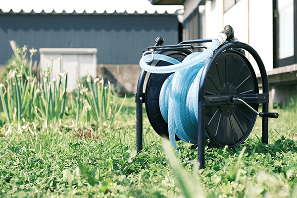 Garden hose on reel in outdoor setting, Convenient water hose for gardening use